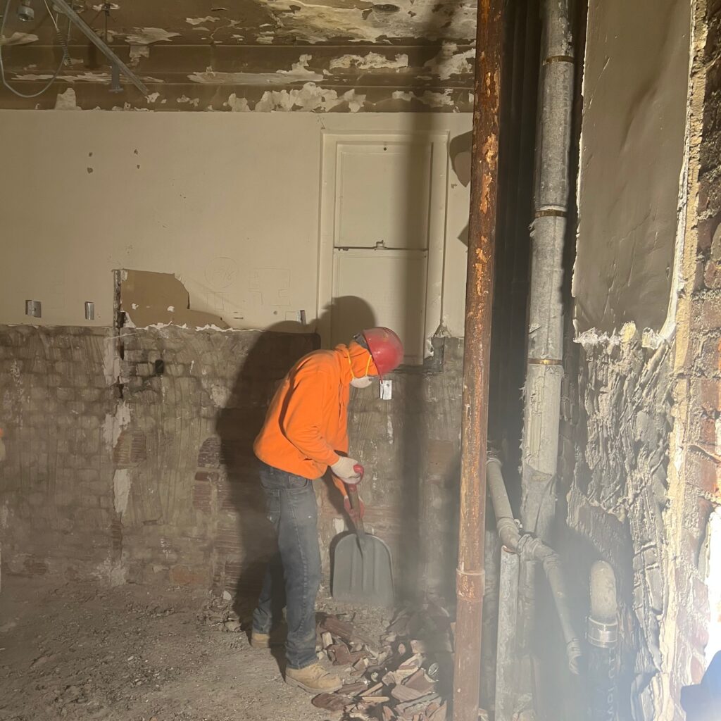 Andrew Horan Alba guiding a construction and demolition team on a New York City job site with skyscrapers in the background.
