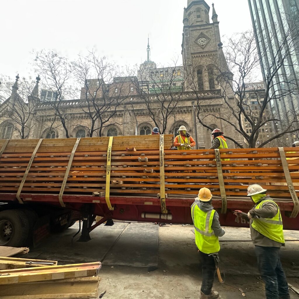 Andrew Horan Alba supervising NYC construction and demolition operations with safety gear, modern equipment, and city skyline in the background.