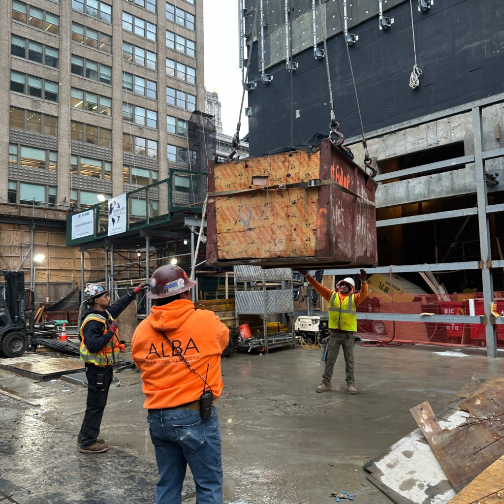 Andrew Horan Alba supervising NYC construction and demolition operations with safety gear, modern equipment, and city skyline in the background.