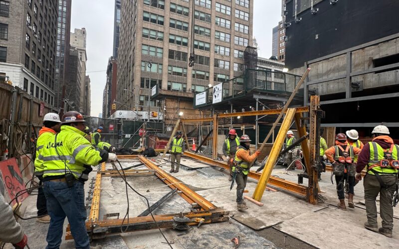 Andrew Horan Alba supervising NYC construction and demolition operations with safety gear, modern equipment, and city skyline in the background.